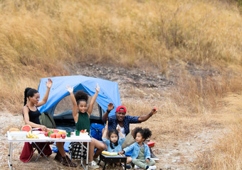 Family Enjoying Camping Holiday. Family interacting while having fruit and solf drink outside the tent at campsite