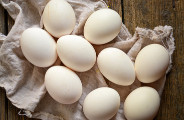 Raw whole eggs on a wooden background. Top view. Dark background. Free space for text. Healthy breakfast.