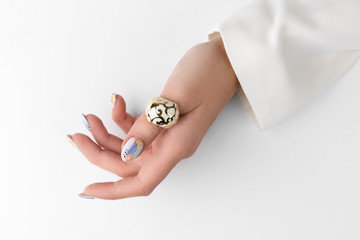 Young adult woman's hand with fashionable nails on white background