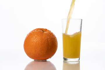 pour orange juice into a glass. orange on a white background