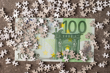 Puzzle pieces and euro bills