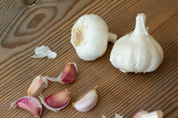 Two heads of white garlic and garlic cloves.