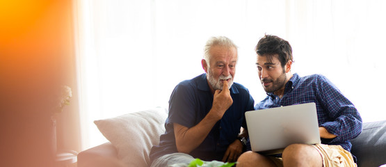 Father and son family time together at home concept. Smiling old father and happy son sitting on...