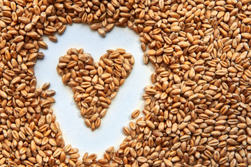 Grains of ripened beautiful wheat in the shape of a heart, harvesting in autumn.