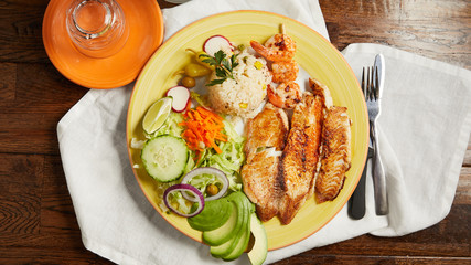 A traditional Mexican food plate of tilapia, rice and veggies 