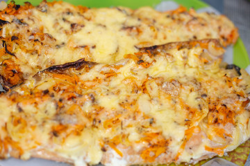 Obraz na płótnie Canvas in a plate baked tasty red fish with vegetables and cheese,