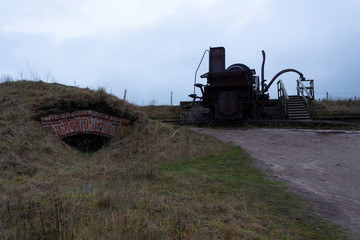 Fototapeta premium The case and the turning mechanism of a large old cannon from the time of the Russian Empire near fortifications in the historical fort Suomenlinna, in Helsinki, Finland, autumn day