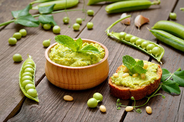 Homemade green pea puree in wooden bowl