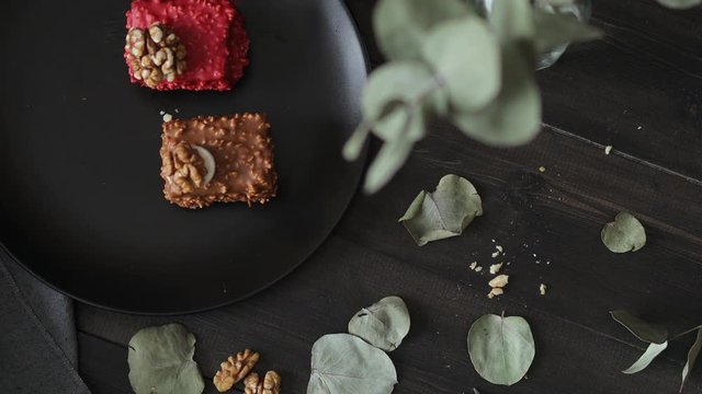 brown and red cakes cupcake with colored chocolate glaze served on a black plate stylish composition with walnut