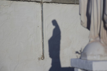 Shadow on a wall of a statue of the Madonna - 340373850