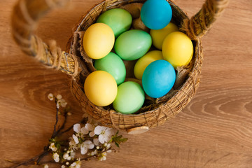 Fototapeta na wymiar painted eggs in a basket on a wooden background