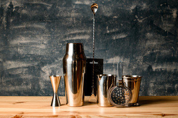Close-up. Several steel items of bar equipment stand at the bar.