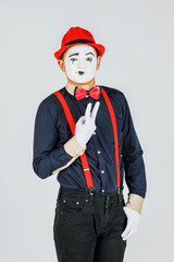 Clown with red suspenders and red hat on white background