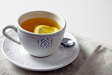 White cup of tea with lemon slice close-up. Homemade cozy tea