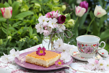 Tischdekoration mit Käsekuchen im Frühlingsgarten