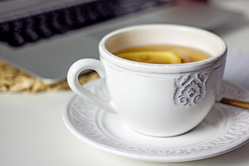 White cup of tea with lemon slice close-up. Homemade cozy tea