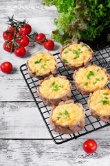 Mini pies with rye dough and mashed potato filling on the metallic lattice. Karelian Kalitki,...