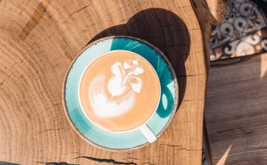Soft focus on latte coffee cup. Hot milk art coffee on wooden table in cafe.