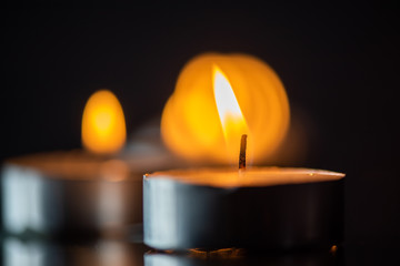 Several candles burning in a row. Photographed close-up.