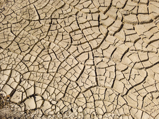 Overhead top view of dry arid soil with cracks during intense heat. Lack of water on agriculture field. Concept of global warming.