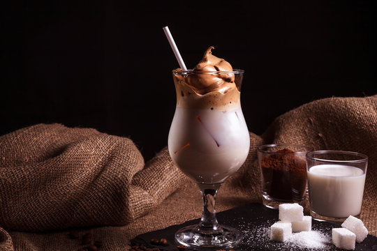 Cold trendy drink Korean dalgon iced coffee on a dark background. delicious and popular coffee in the trend