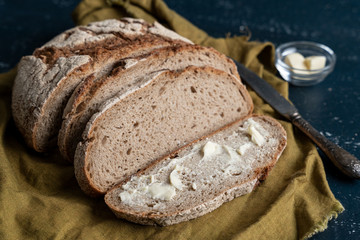 Homemade reshly baked country bread made from wheat and whole grain flour sliced with butter