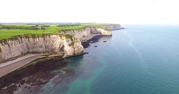 cliffs of Etretat in Normandy, France. Cliffs white work of nature, drone photos, camera movement to the side, view of golf courses, rocks, beaches and sea, shot in the early day, summer. 4k25ftp
