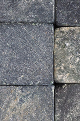 Stone background close-up. Natural texture. Light gray bluish backdrop or wallpaper. Rough surface. Reduced contrast. Vertical shot. Macro