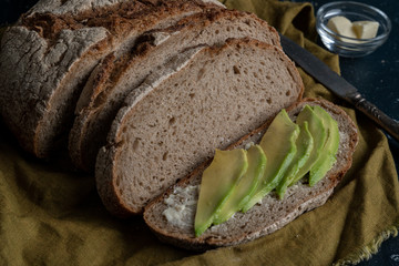 freshly baked country bread sliced with butter and avocado