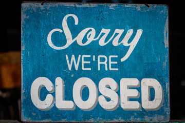 Sorry, we're closed sign standing in a shop window