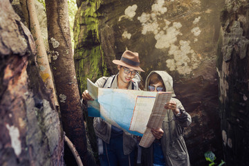 Men and women are using the map to see hiking trails. Travel who like to challenge and relax. The concept of camping and hiking. 