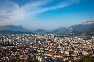 Wispy clouds over Grenoble france on a sunny day with lots of blue sky and mountains