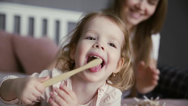 Little girl brushing her teeth and tongue with a bamboo toothbrush