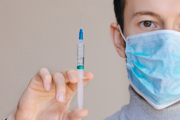 Male person in white glove hold vaccine bottle with syringe. Inj
