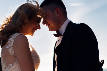 Closeup of newlyweds closed their eyes and hold their hands on t