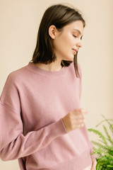 Shooting studio portrait of young  woman in jersey on beige background. Relax and mordern concept.
