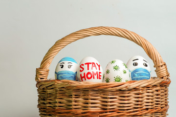 Easter eggs in a basket on a white background with the inscription sit at home