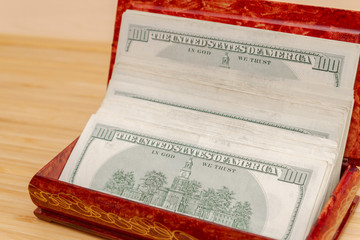 American hundred dollar bills in large quantities in a wooden box