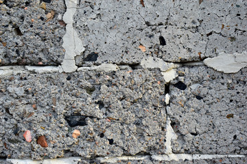 An old wall of gray crumbling cinder block