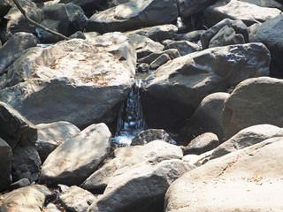 huge stone boulders and a stream running through them