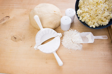 National Russian cuisine. Pierogi or pyrohy, vareniki, served with cottage cheese and potatoes on board.  Raw dumplings made of dough in handmade flour