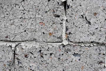 An old wall of gray crumbling cinder block