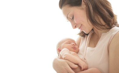Mother and her Newborn Baby together. Love. Happy Mother and Baby kissing and hugging. High key...