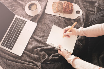 Obraz premium woman work at home for stay home order of coronavirus pandemic .online working and learning on bed with the laptop, mobile phone and good vibe.
