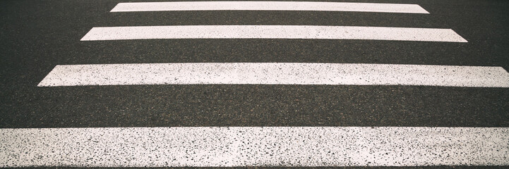 modern pedestrian crossing with white stripes on city road at sunlight closeup