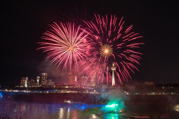 Fireworks seen on the United States side of Niagara Falls in the summer. Pink background, exciting, exploring. 