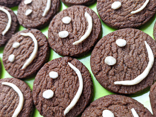 Chocolate cookies with smilies in top.