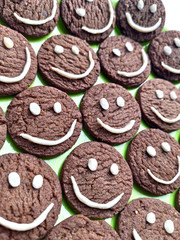 Chocolate cookies with smilies in top.