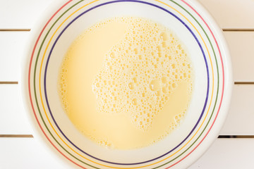 Bowl with beaten eggs milk flour for cooking pancakes - 340399819