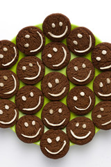 Chocolate cookies with smilies in top.